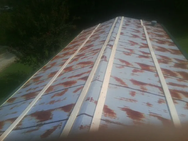 Rusted metal roof panels with new wood purlins before replacement — Storm Damage Roof Repair in Concord by Roofing Brothers